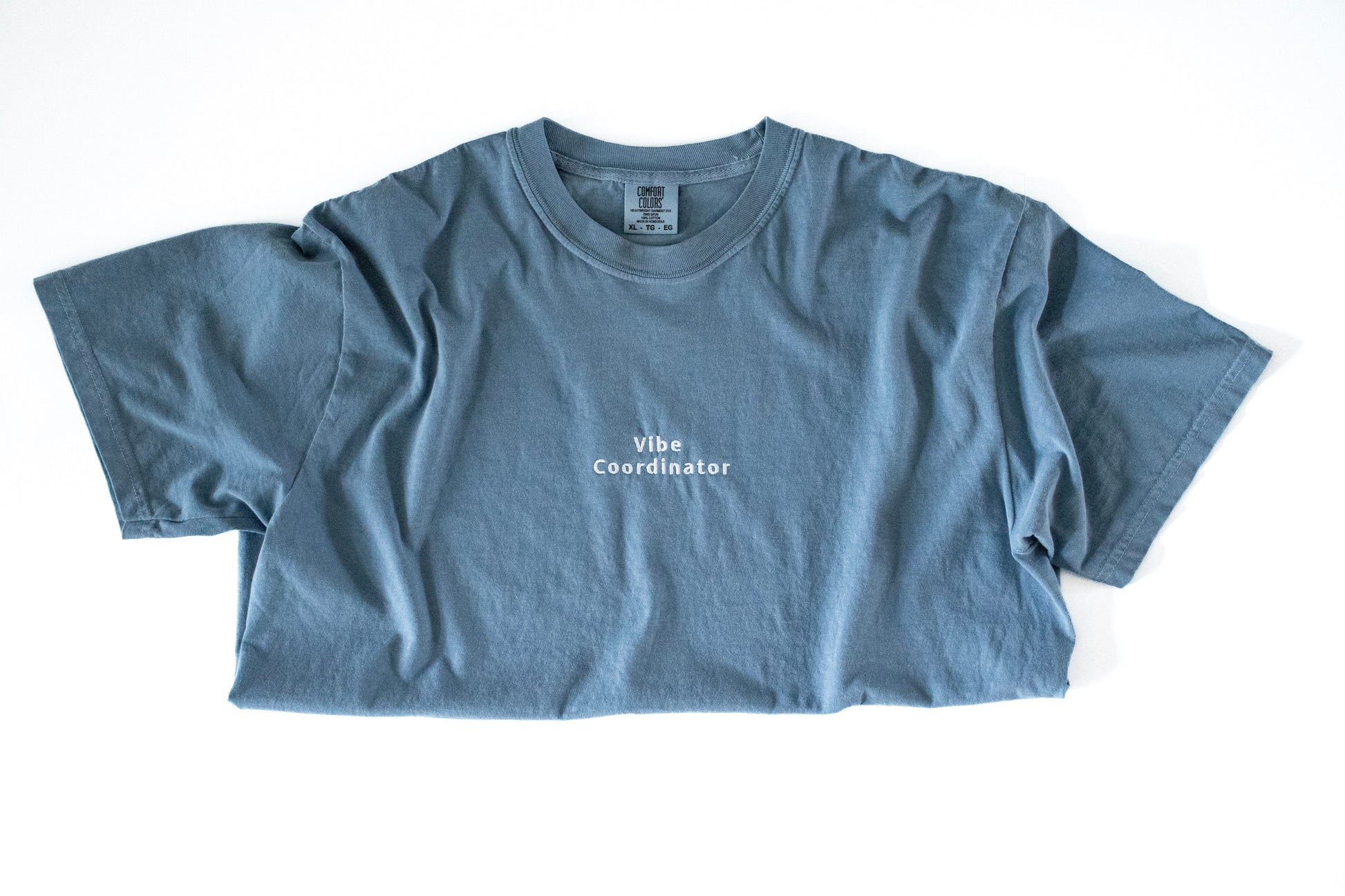 Blue t-shirt with 'Vibe Coordinator' text on a white background