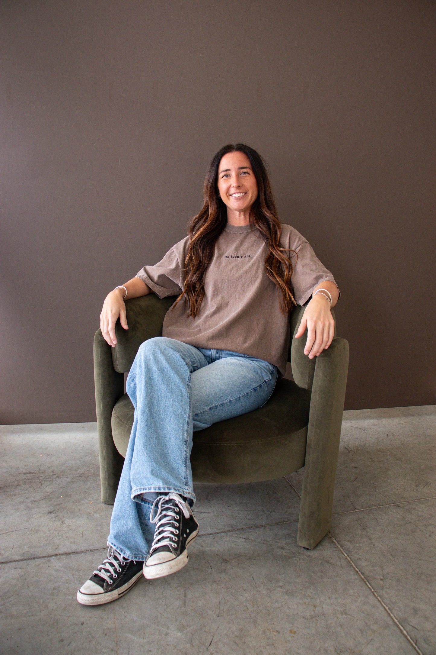 Do iconic shit embroidered tee woman sitting in green chair 
